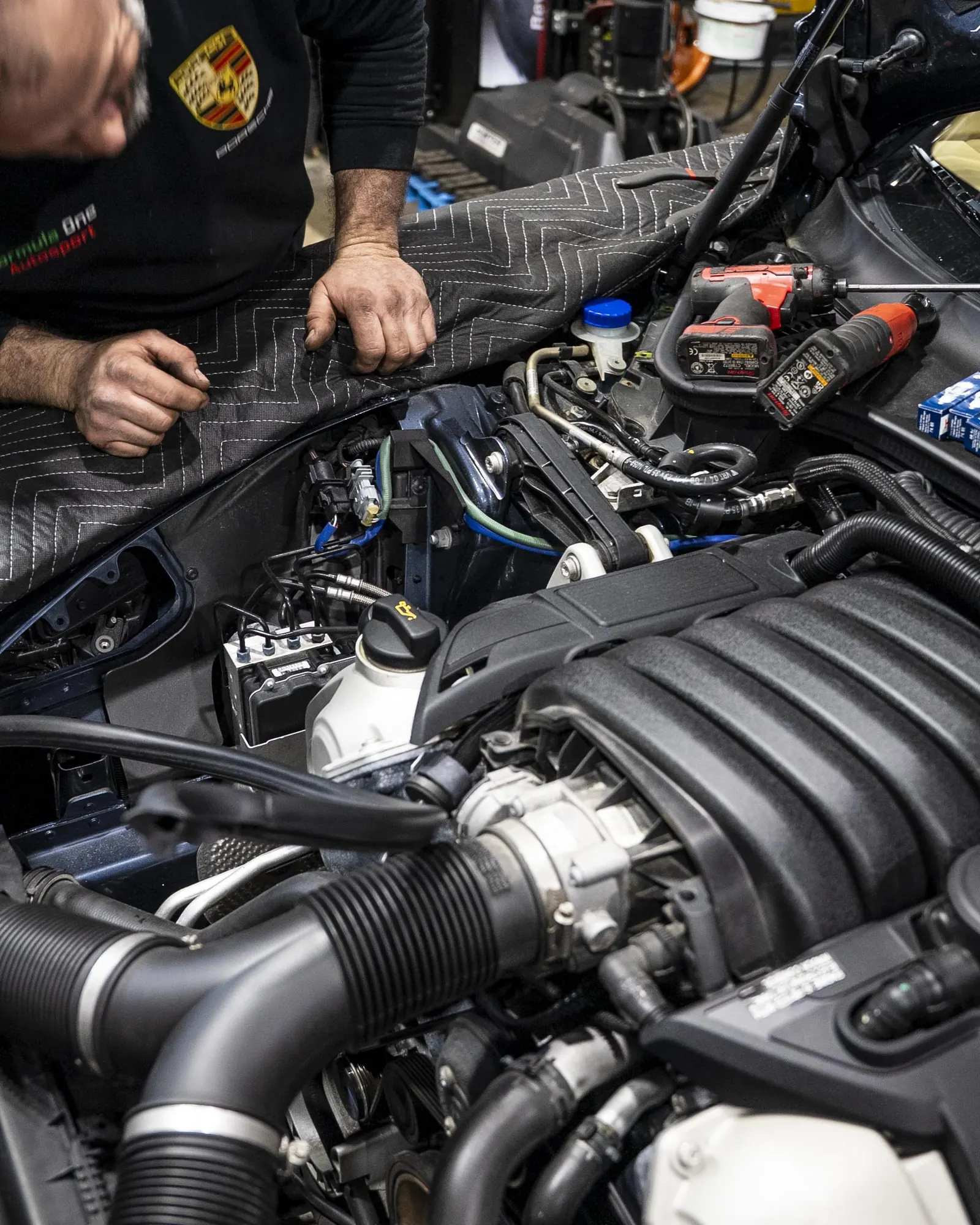 Technician performing engine bay diagnostics at Prestige Performance Center