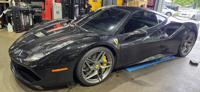 Black Ferrari 488 in the bay beside the Road Force balancer