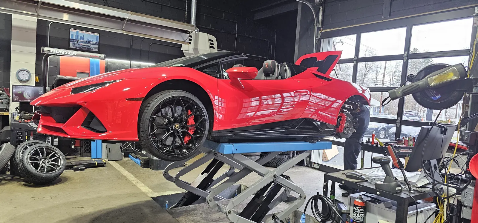 Lamborghini Huracan EVO Spyder on the lift for brake service — carbon-ceramic rotors exposed