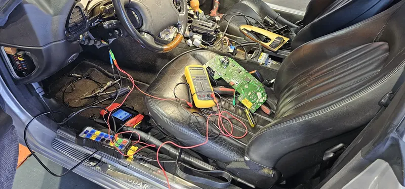 Pin-level electrical diagnosis — breakout box and meter on a Jaguar