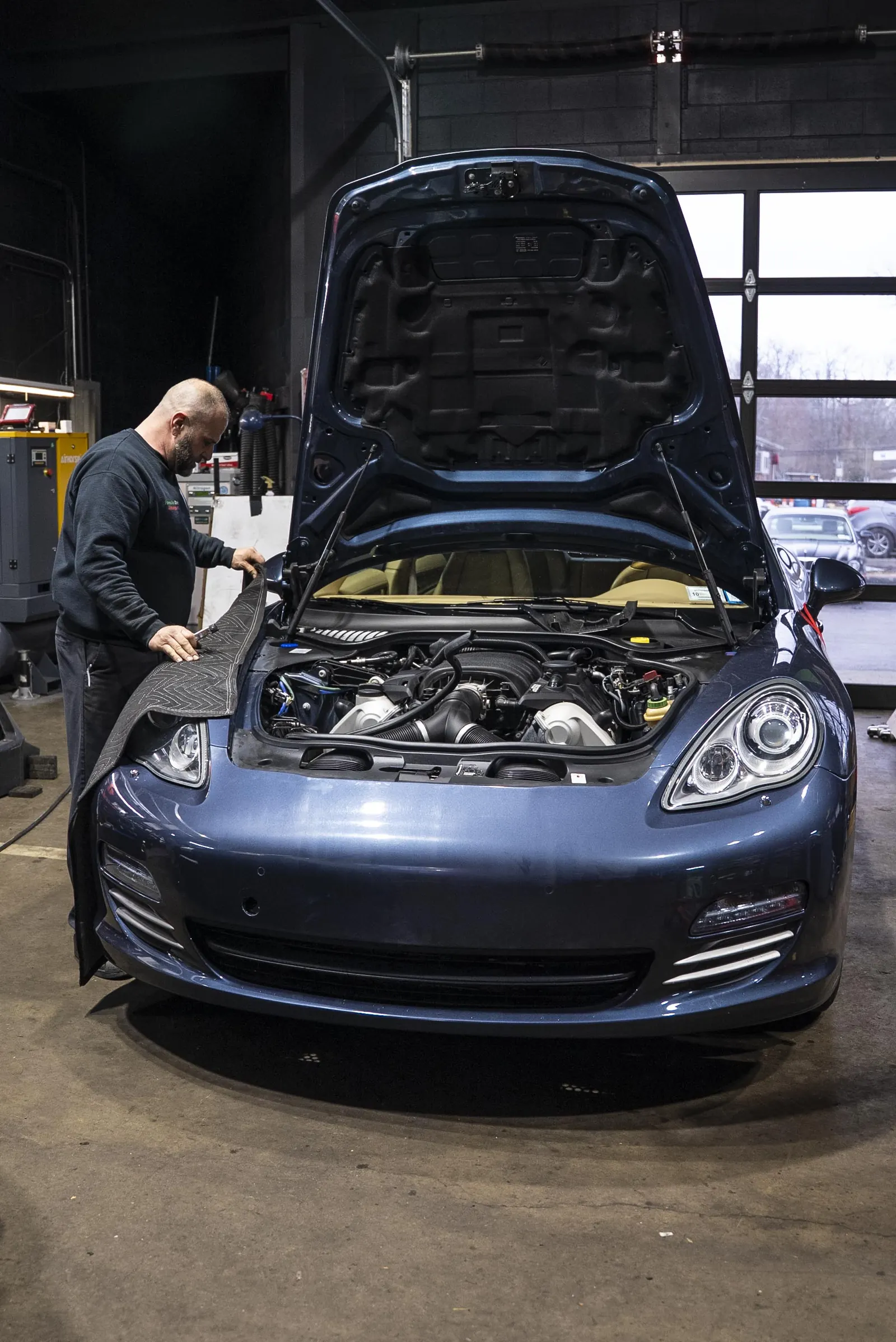 Fender covers protecting a Porsche before service begins