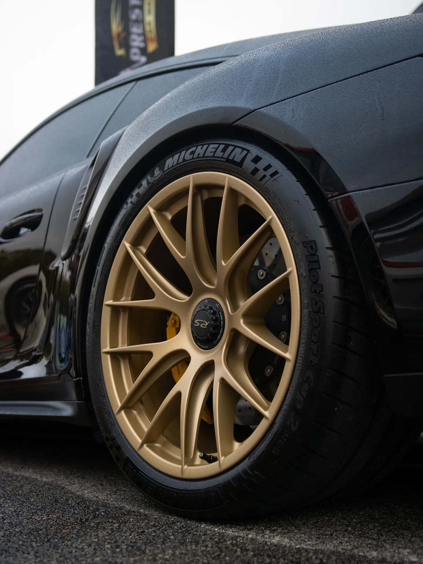 Satin gold powder coated centerlock RS wheel on a black Porsche at Prestige Performance Center