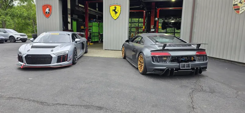R8 LMS GT4 and the twin-turbo R8 between the Lamborghini and Ferrari shields