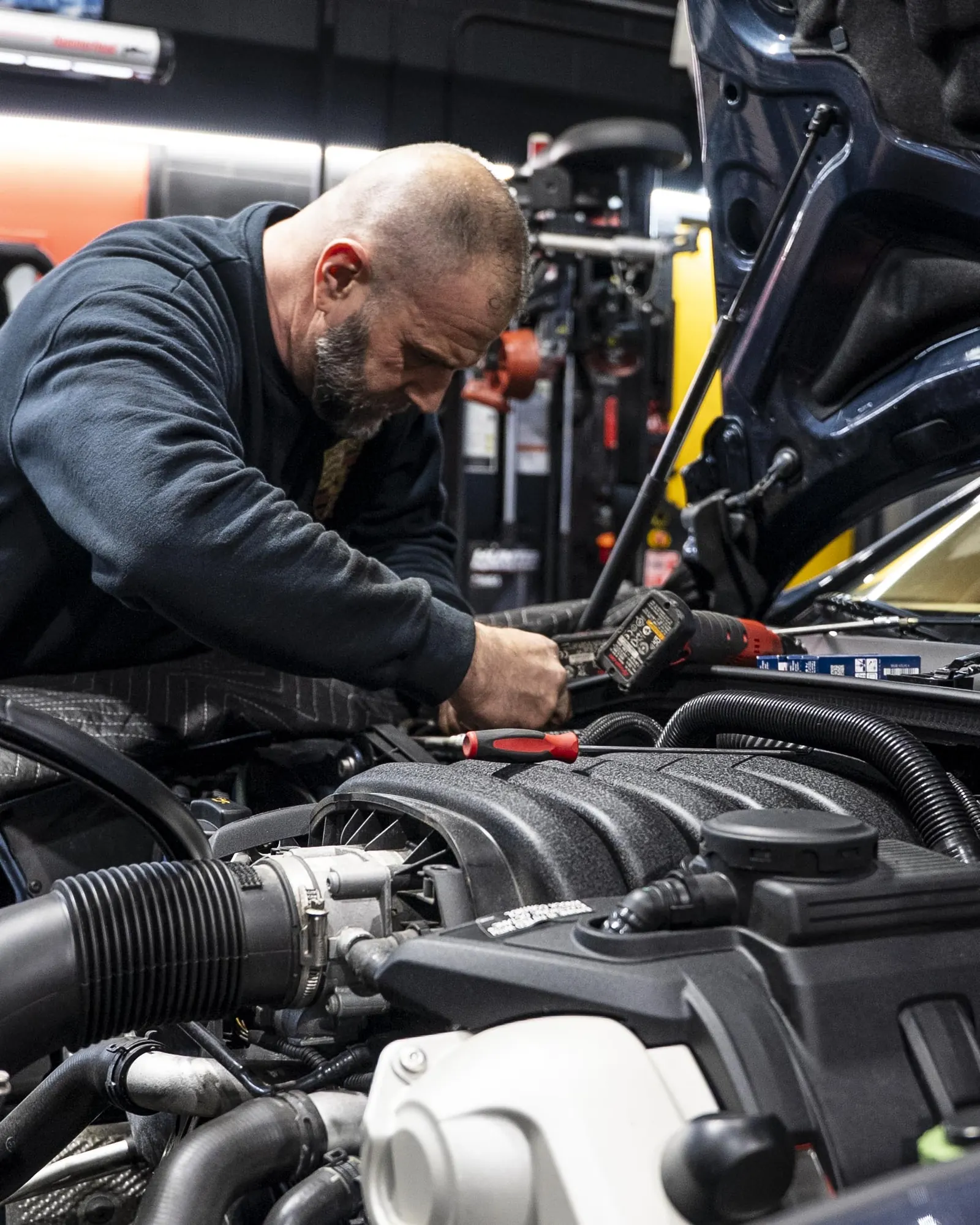 Technician diagnosing an engine bay with professional tools