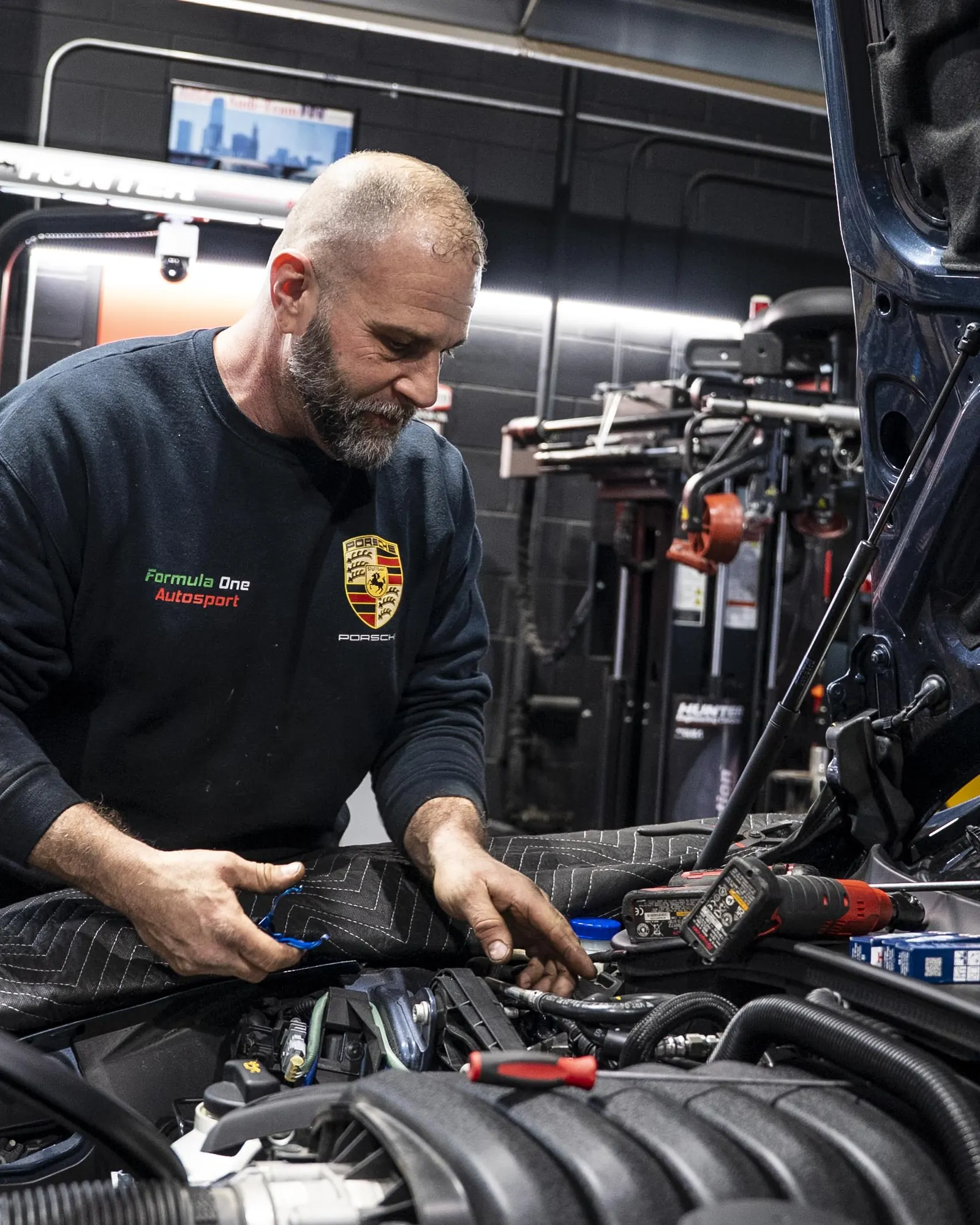 Technician performing under-hood AC system service