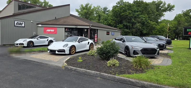 A pair of white 992 Turbo S and an Audi RS7 out front